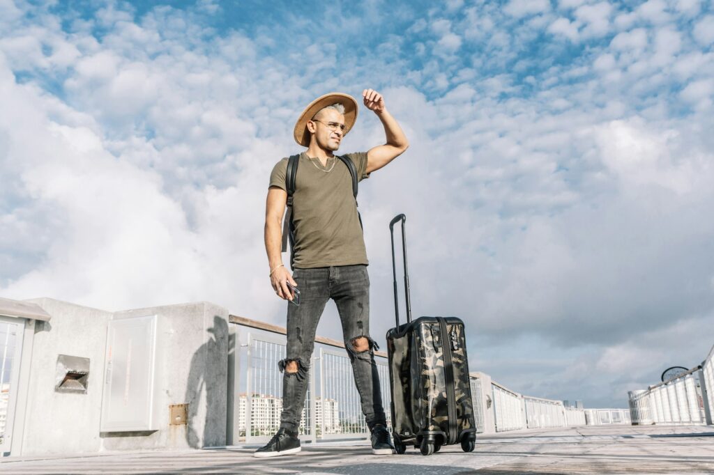 Full length portrait of a lost handsome man with a suitcase searching for a way